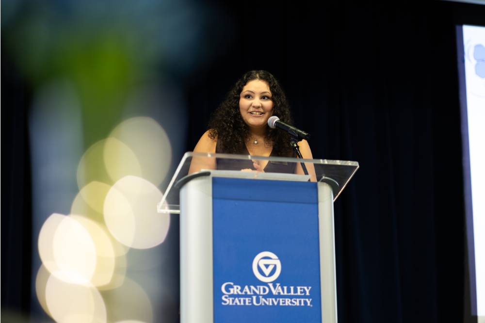 Image 1 of 2 Person speaking into a microphone